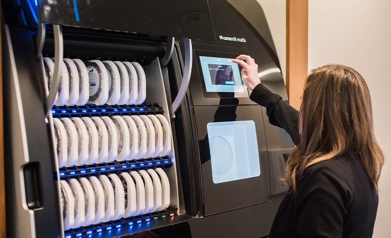 Woman using CEREC in office dental restoration milling unit