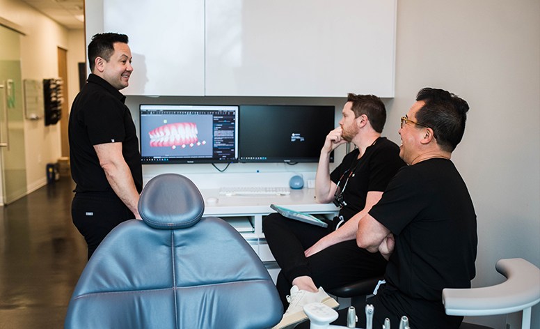 Friends sharing smiles after full mouth reconstruction