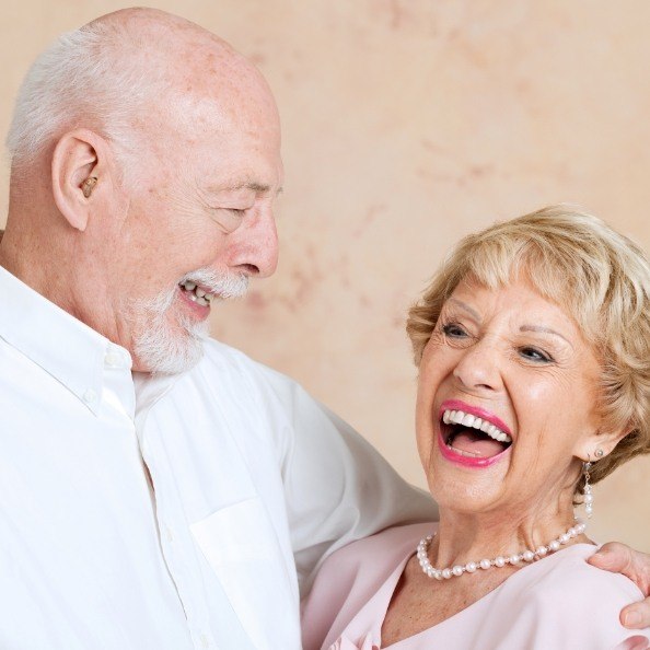 Man and woman with healthy smile after dentures