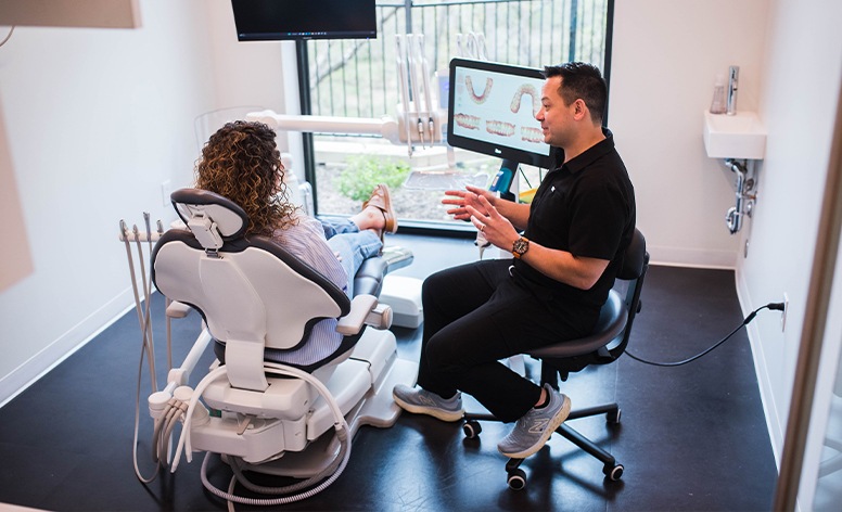 Dentist and patient laughing together during mouthguard crafting