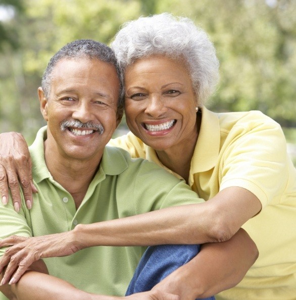 Older couple with dental implant supported dentures smiling together