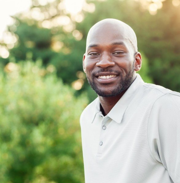 Man smiling after tooth replacement with dental implants