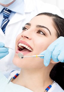 dentist looking in patient’s mouth 