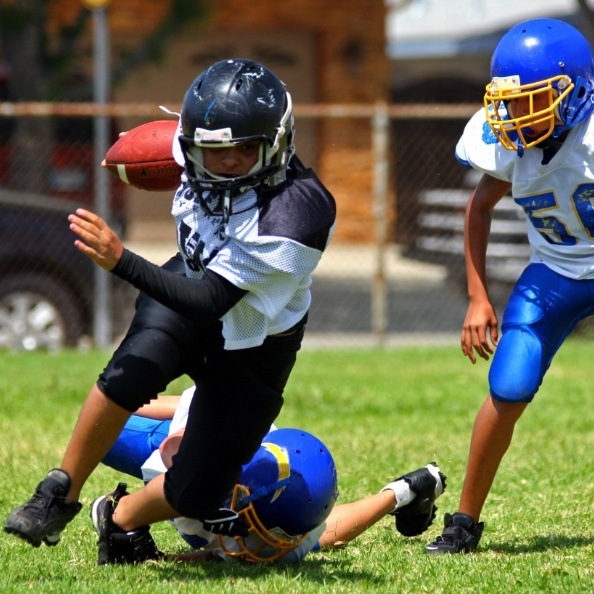 Teens with athletic mouthguards playing football