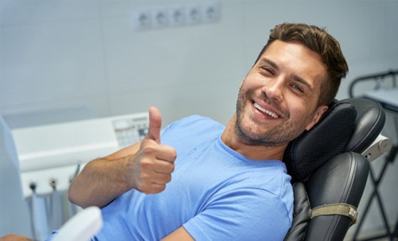 Male dental patient giving a thumbs up