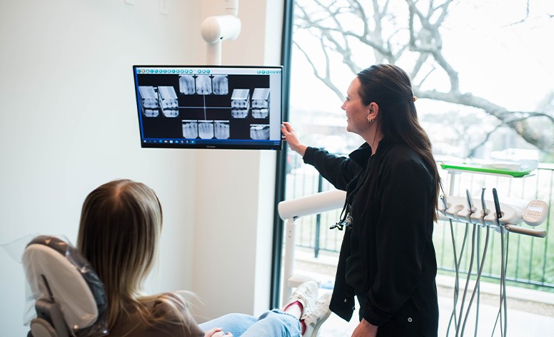 Dentist and patient reviewing digital technology on tablet computer