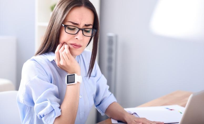 Woman in pain caused by teeth grinding