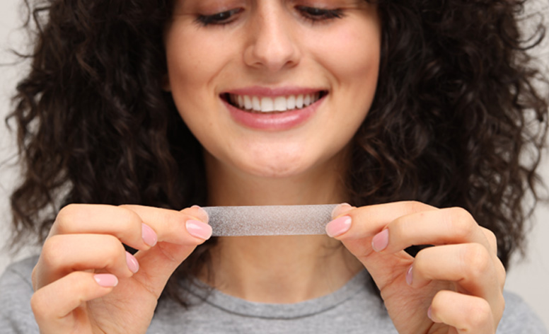 Woman holding a whitening strip