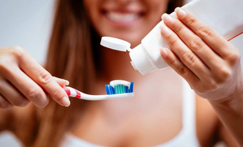Woman holding toothbrush and toothpaste