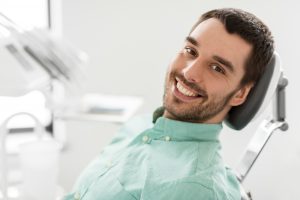 young man smiling receiving dental care