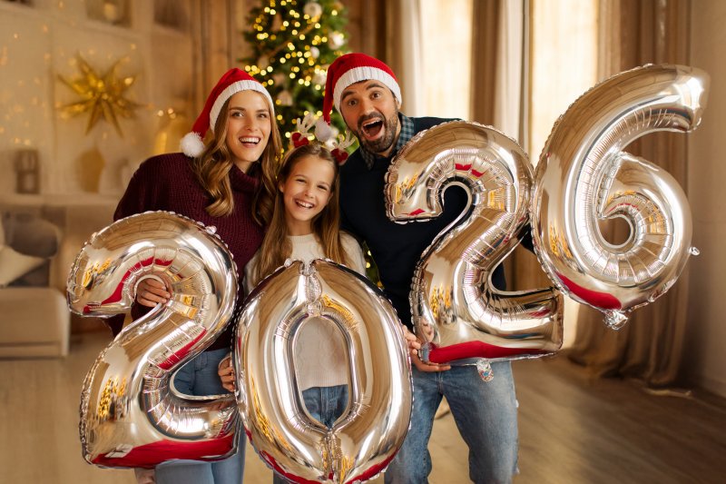 A family holding balloons that spell “2026
